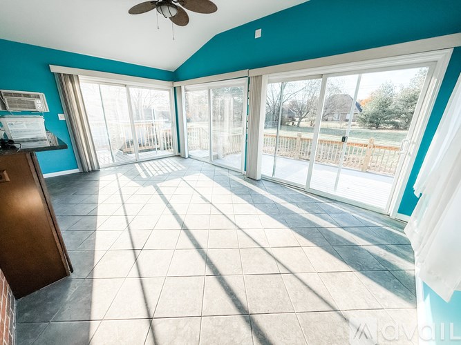 A kitchen with a refrigerator, dishwasher, and a chair.
