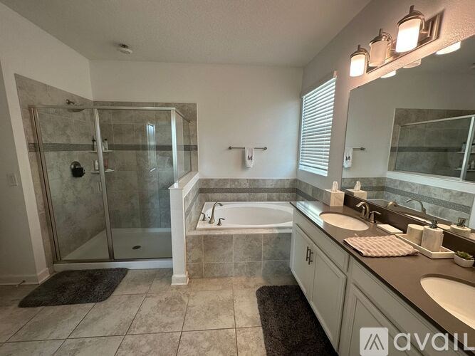 A bathroom with a walk-in shower, a bathtub, and a double sink vanity.