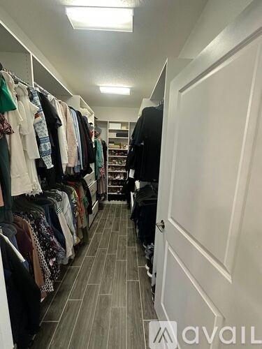 A row of clothes hangs on a rack in a room.