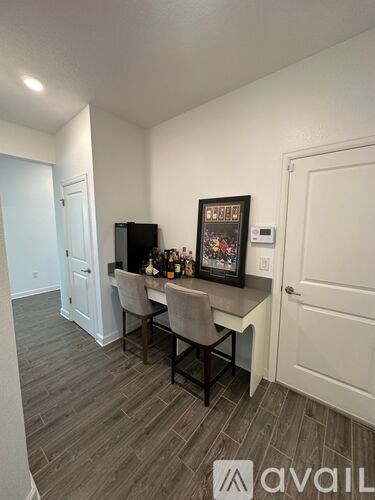 A room with a desk and chairs in it.