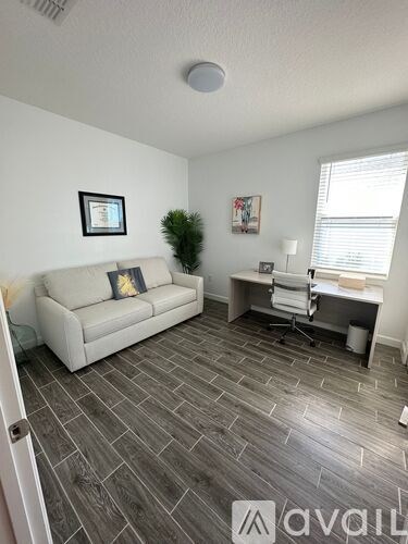 A living room with a couch, chair, and desk.