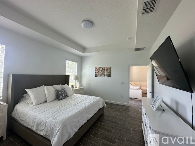 A bedroom with a large bed and a flat screen TV.