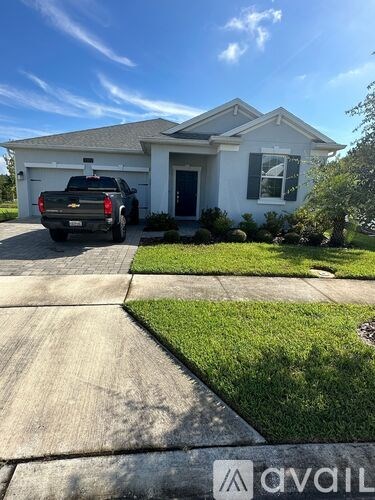 A house with a white picket fence and a truck parked in front.