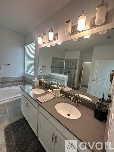 A bathroom with a large mirror and lights above it.
