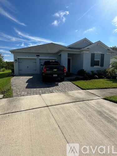 A house with a black truck parked in front of it.