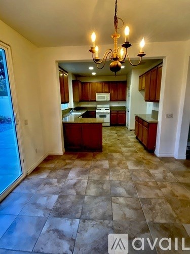 A kitchen with a chandelier and a tiled floor.