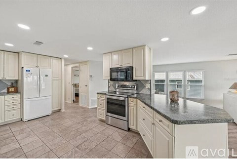 A kitchen with white cabinets and a granite countertop.