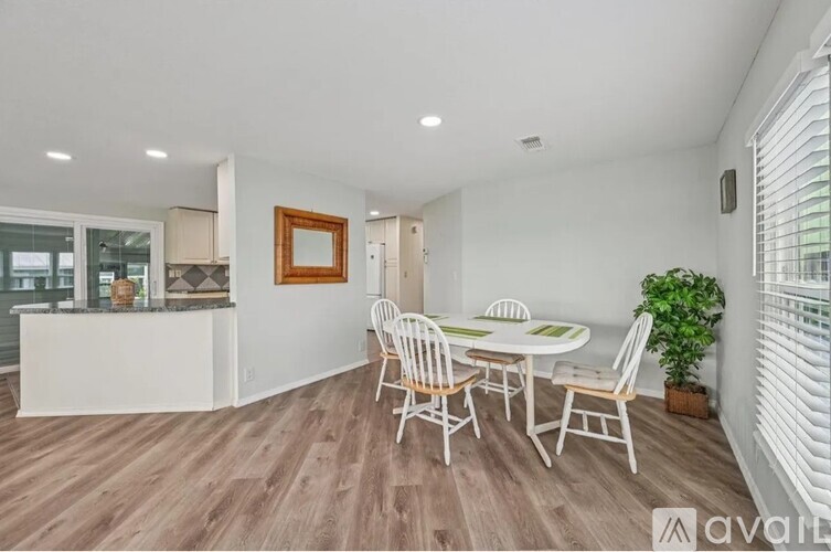 A dining room with a white table and chairs.