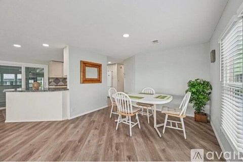 A dining room with a white table and chairs.