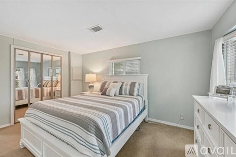 A bedroom with a large bed and a dresser.