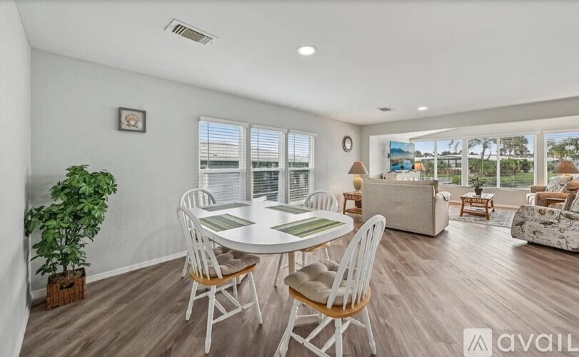 A living room with a dining table and chairs.