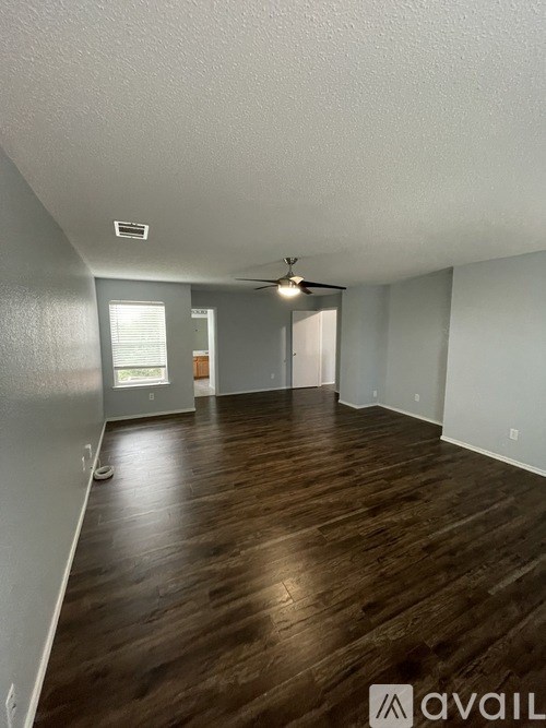 A room with wooden floors and a ceiling fan.