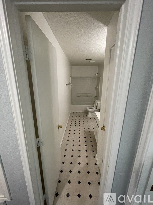 A hallway with a tiled floor and white walls.