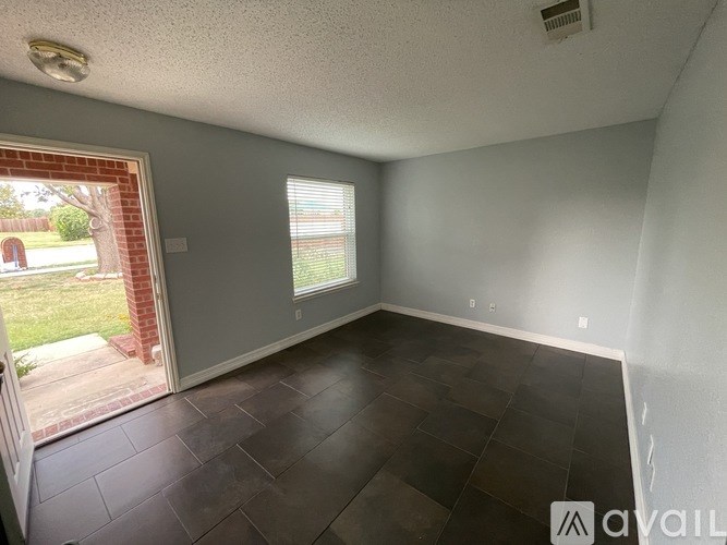 A room with a sliding glass door leading to a backyard.
