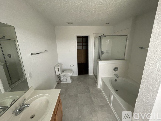 A bathroom with a white tub, sink, and toilet.