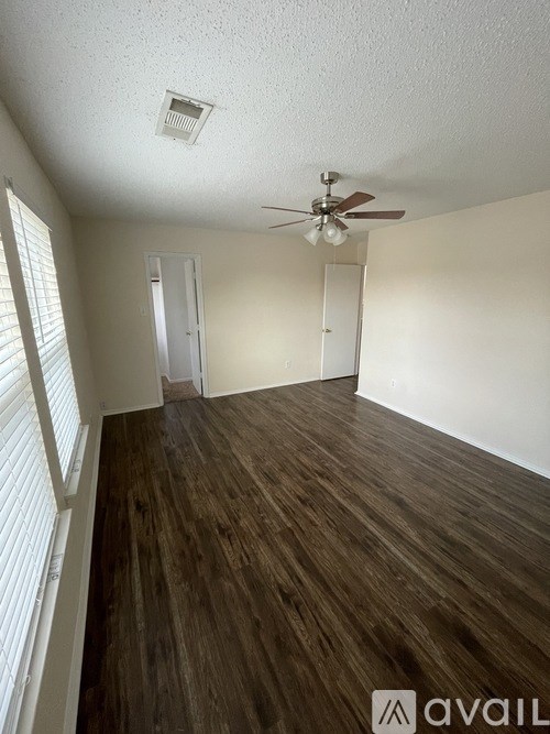 A room with wooden flooring and a ceiling fan.