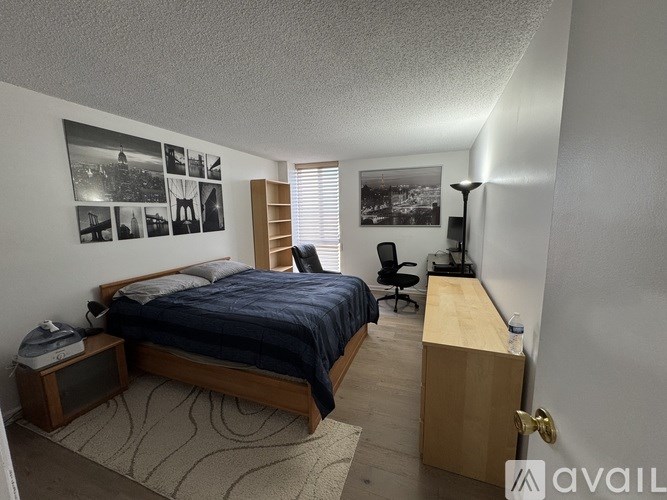 A bedroom with a bed, desk, and chair.