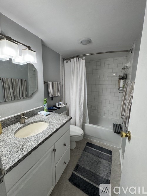 A bathroom with a granite countertop and a white sink.
