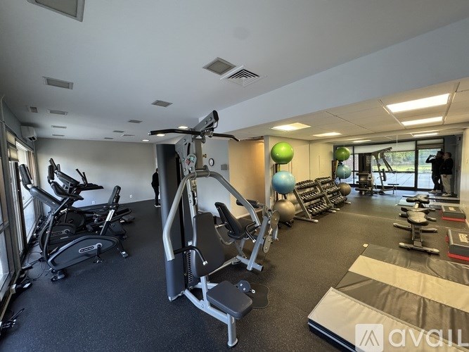 A gym with a variety of equipment including treadmills, stationary bikes, and weight machines.