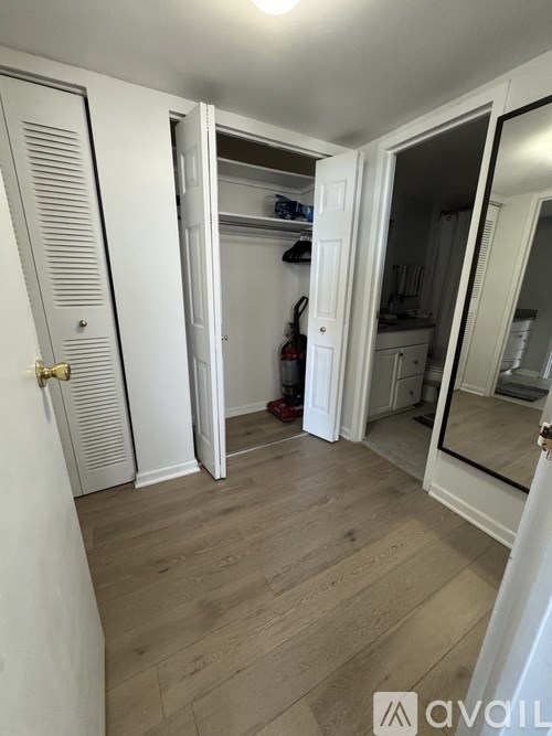 A white door with a gold handle is open to a kitchen.