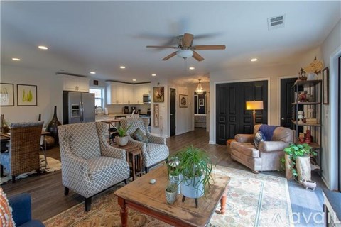 A living room with a wooden coffee table and a ceiling fan.