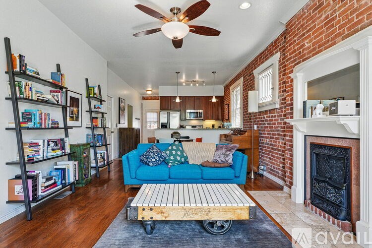 A living room with a blue couch and a fireplace.