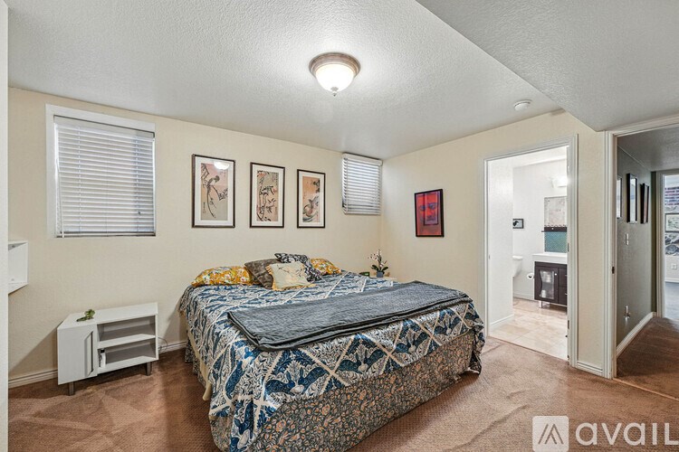 A bedroom with a bed, a nightstand, and pictures on the wall.