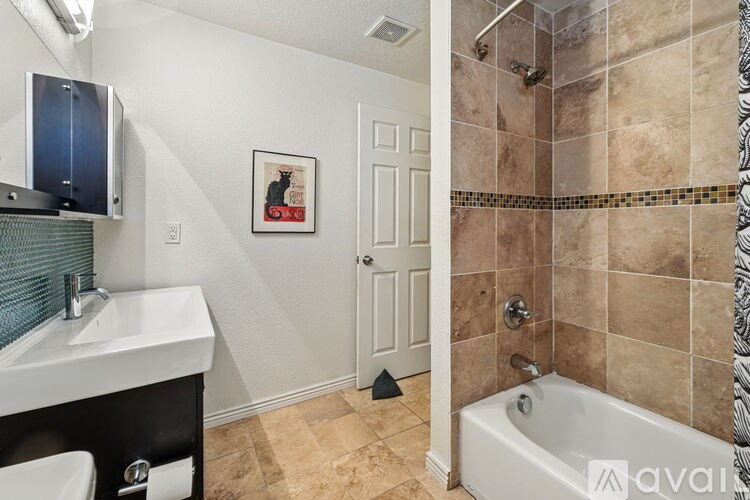 A bathroom with a white sink and a white bathtub.