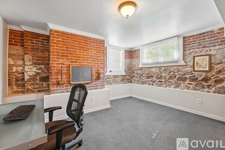 A room with a brick wall and a window with blinds.