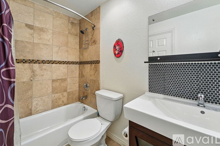 A bathroom with a toilet, sink, and bathtub.