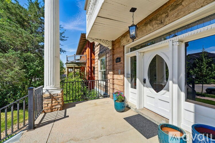 A white door is on the right side of a porch.