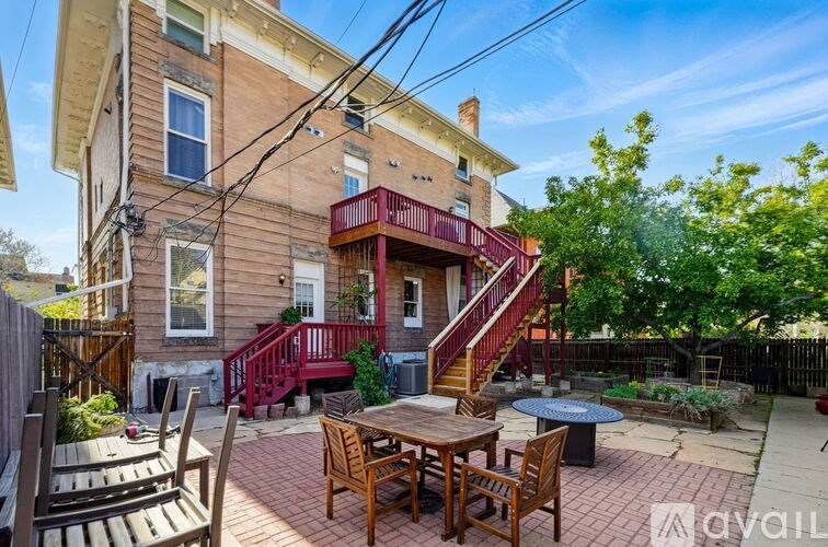 A house with a red staircase and a patio with a table and chairs.