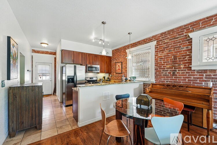 A kitchen with a white countertop and a brick wall.