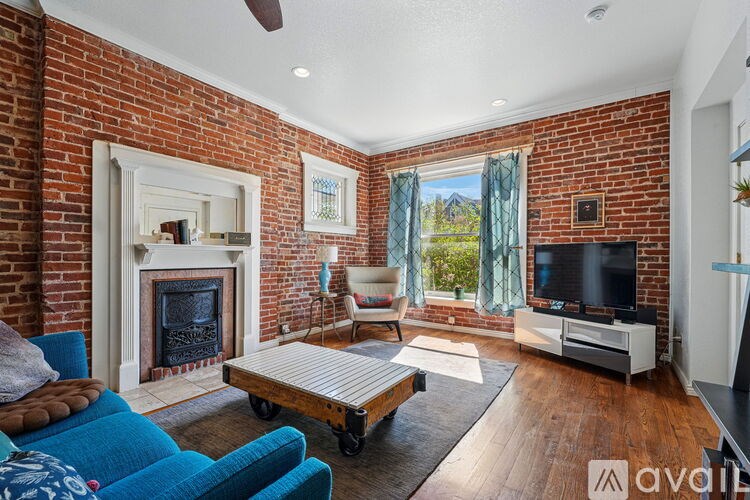 A living room with a brick wall and a fireplace.