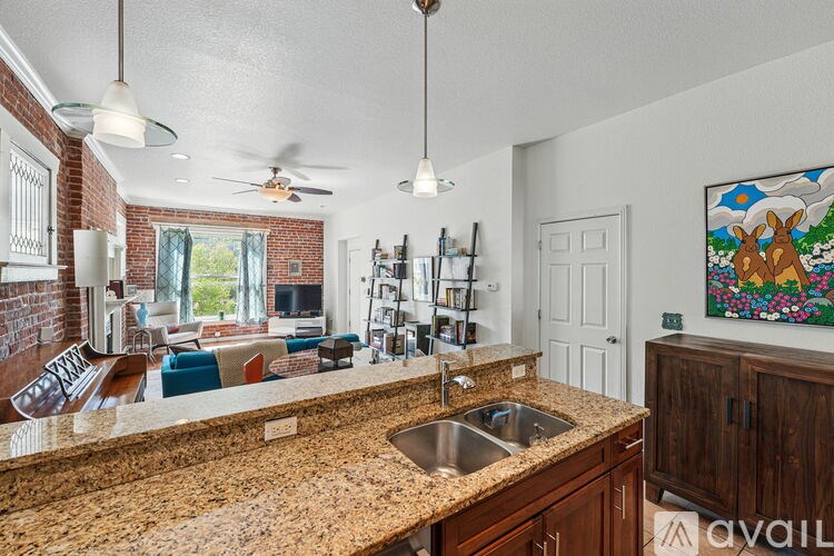 A kitchen with granite countertops and a painting of a moose on the wall.