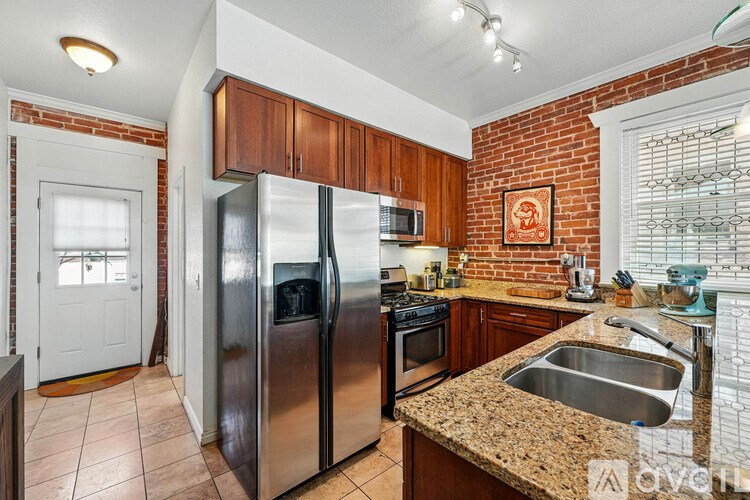 A kitchen with a refrigerator, oven, sink and microwave.