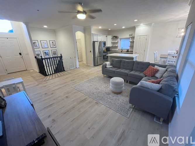 A living room with a grey couch and a wooden floor.
