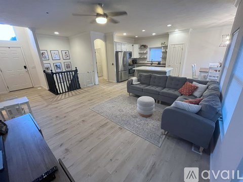 A living room with a grey couch and a wooden floor.