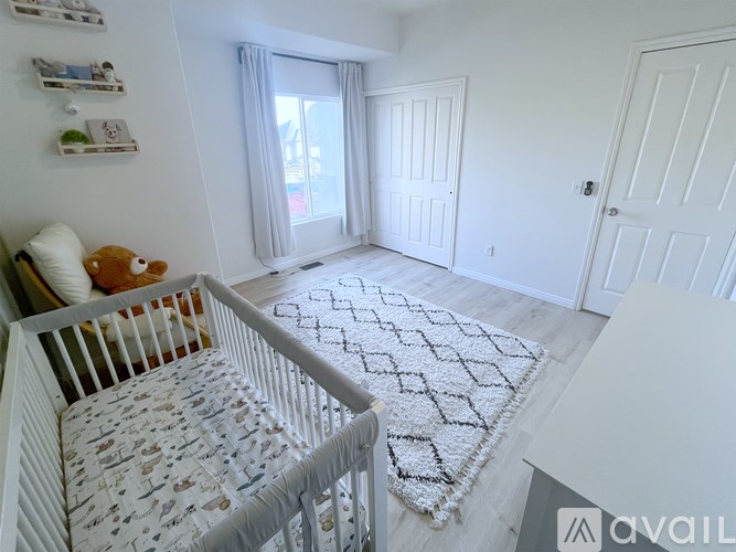 A baby's room with a white crib and a white rug with a black border.