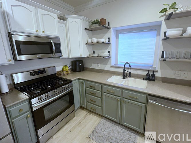 A kitchen with white cabinets and a stainless steel oven.