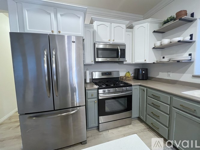 A kitchen with a stainless steel refrigerator and oven.