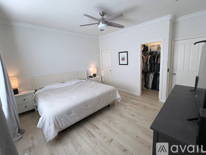 A bedroom with a bed, dresser, and a ceiling fan.