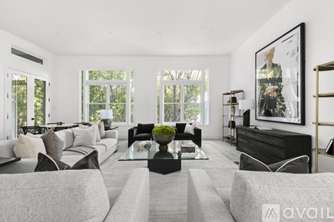 A modern living room with a grey sofa set and a glass coffee table.