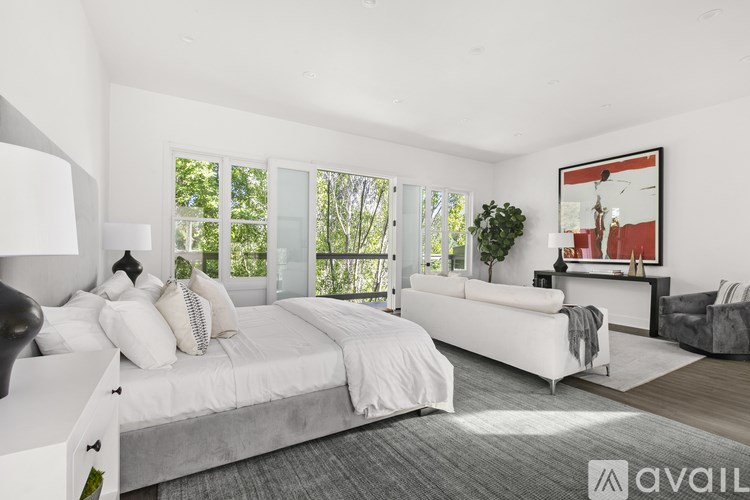 A modern bedroom with a large bed and a couch.