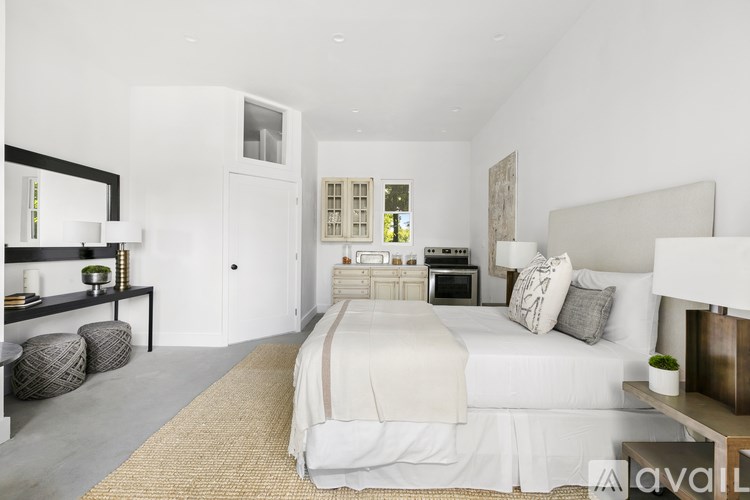 A bedroom with a large bed and a mirror on the wall.