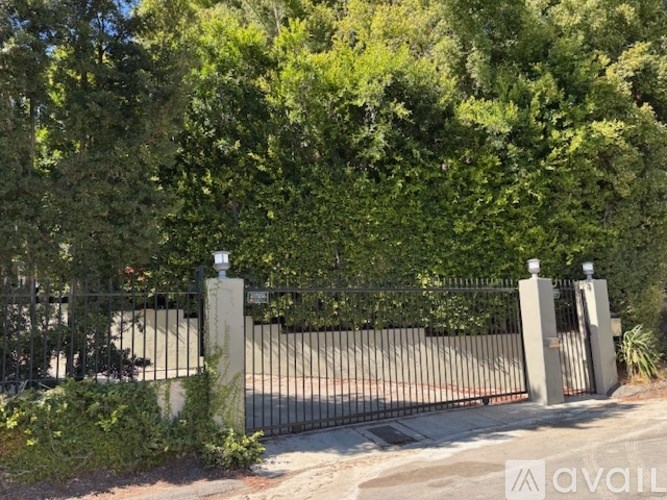 A black metal gate with a stone pillar on either side.