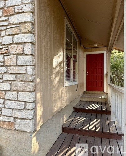 A red door is on the right side of a white wall.