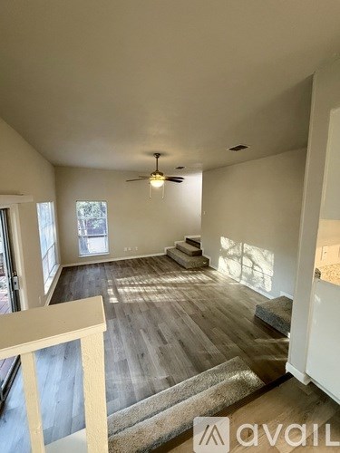 A room with wooden floors and a ceiling fan.