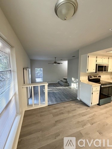 A living room with a kitchen area in the background.