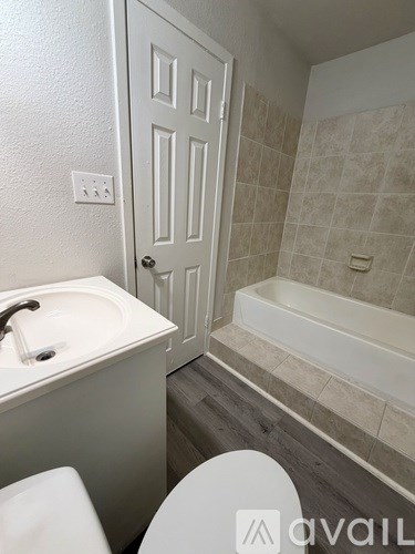 A bathroom with a white sink, toilet, and bathtub.